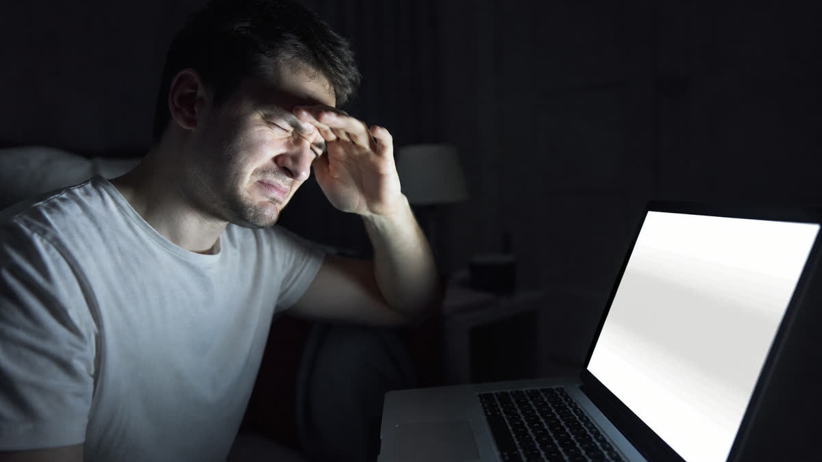 A screen that is too bright for a dark evening room, lighting the viewer’s face with harsh glare.