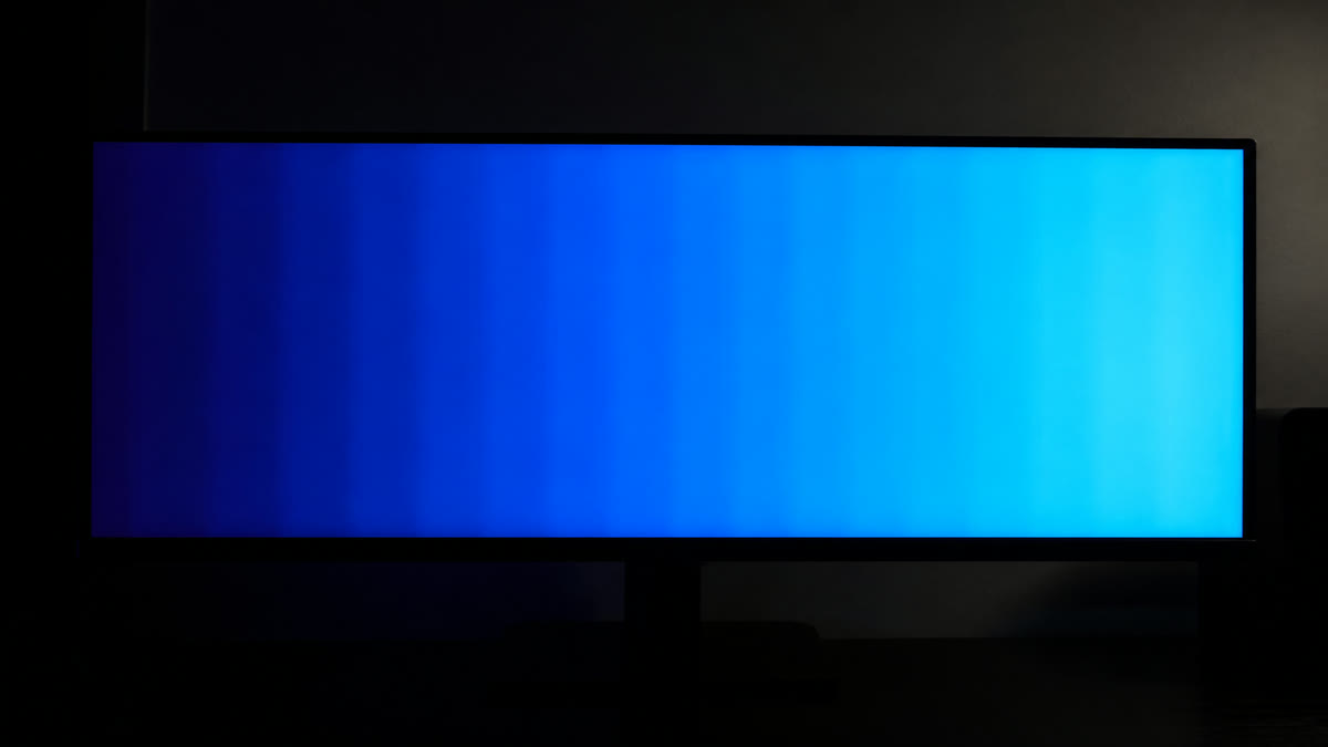 A monitor showing a sky-like blue gradient from navy to cyan with visible rough banding stripes.