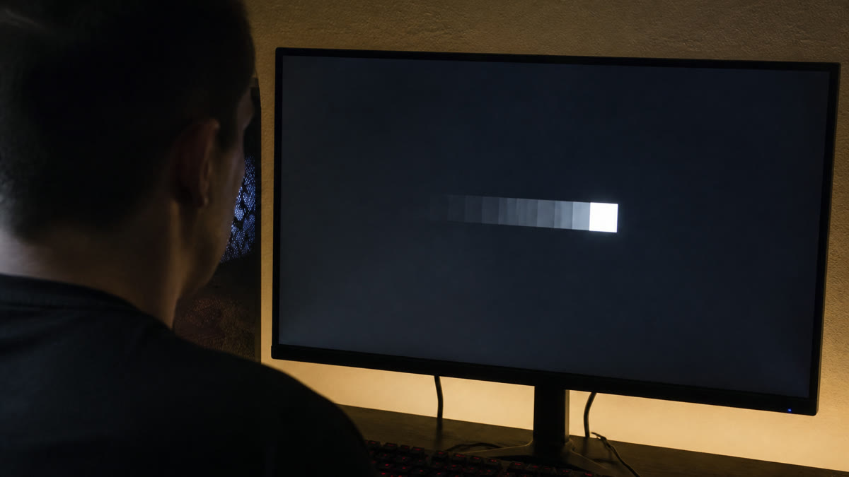 A monitor showing a moving white block with a repeated shadow trail behind it while someone inspects the panel.